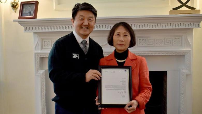 365英国上市杜波依斯分校 chancellor and chief academic officer Jungwoo Ryoo, 正确的, presents Pingjuan Werner with a framed copy of the letter certifying her as a distinguished professor, 这所大学最高的教授荣誉