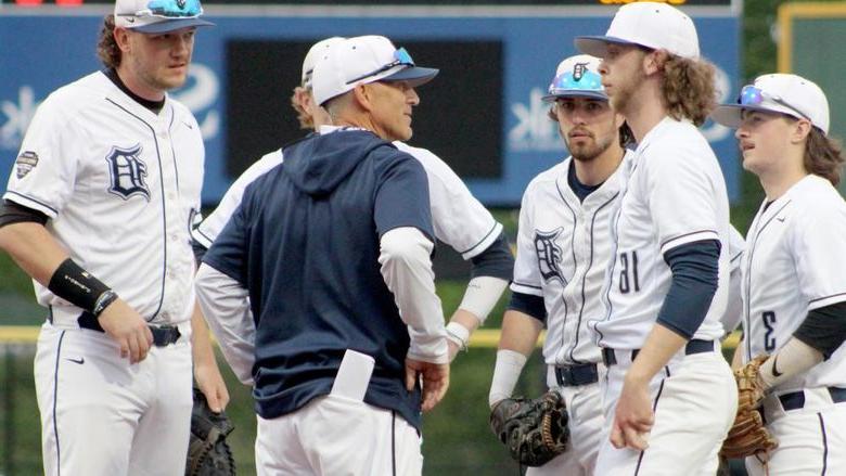 365英国上市杜波依斯分校 head coach Tom Calliari, center, talks with his players during a mound visit in a game during the USCAA Small College World Series.