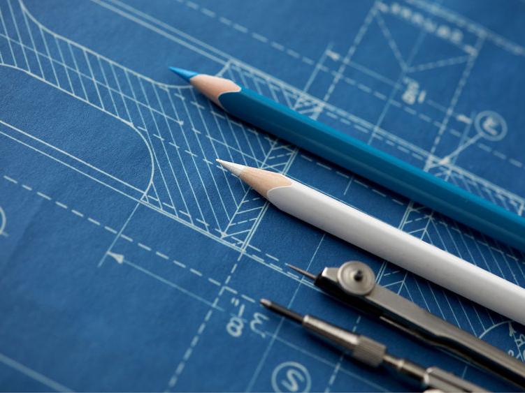 Markup tools lay on top of a blueprint on a table.